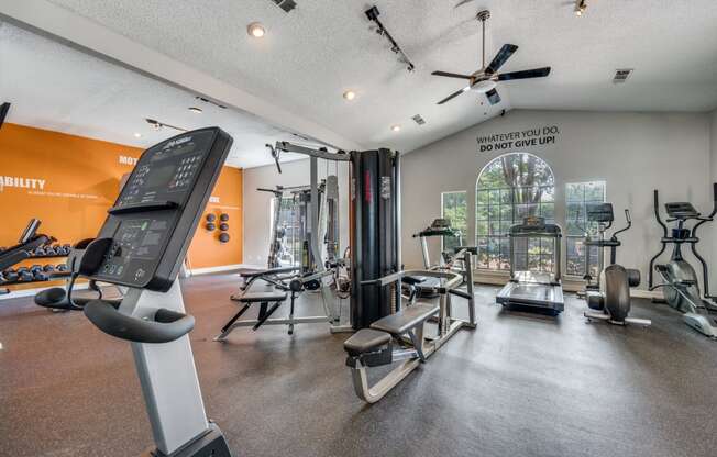 spacious gym with cardio machines and weights at the everyday gardener apartments