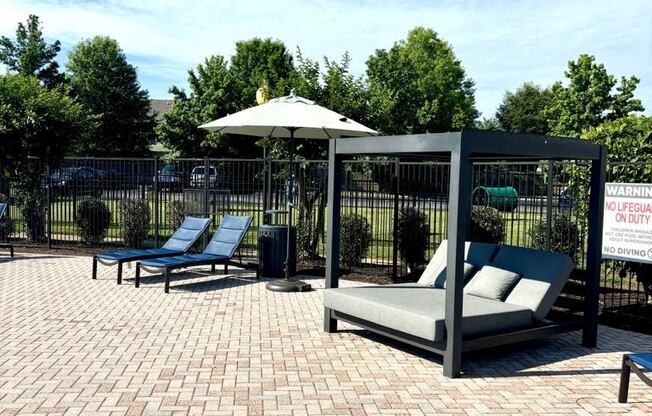 a patio with two lounge chairs and a canopy