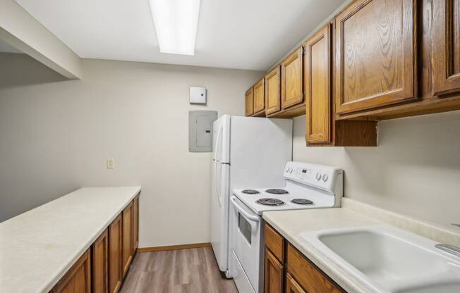 an empty kitchen with a stove refrigerator and sink