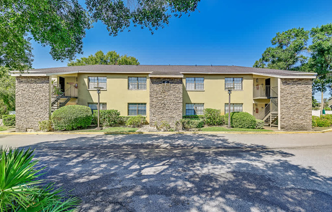 A sunny day at a stone and stucco apartment complex.