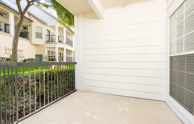 a garage with a fence and an apartment building in the background