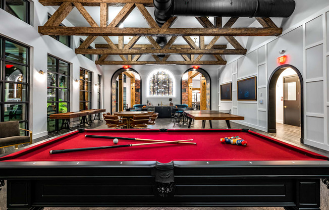 a pool table in the lobby of a building with a lounge area and a large at The Alibi at Lake Lilly, Ocoee, FL, 34761