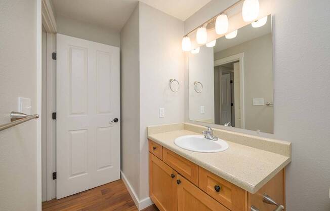 A bathroom with a sink, mirror, and lighting.