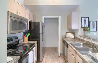 A kitchen with a stove, microwave, and refrigerator.