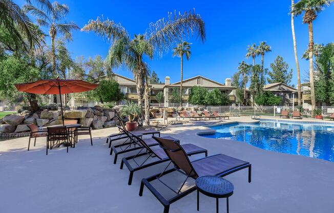 a group of lawn chairs sitting next to a pool of water