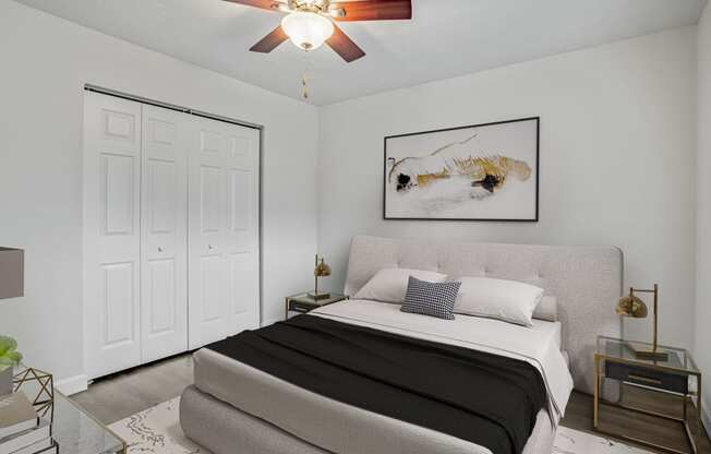 a bedroom with white walls and a ceiling fan