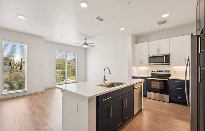 A modern kitchen with dark blue cabinets and stainless steel appliances.