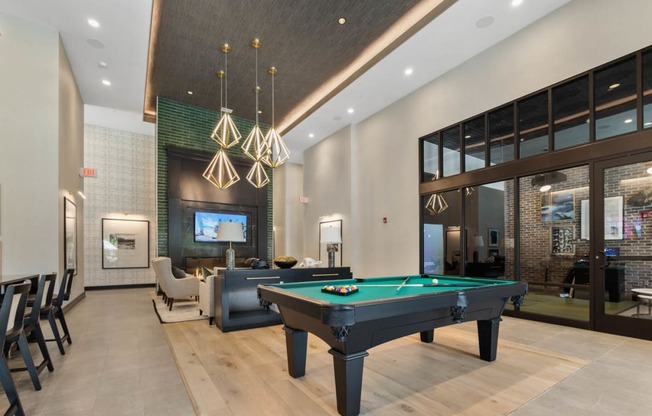 a pool table in the lobby of a clubhouse with a tv