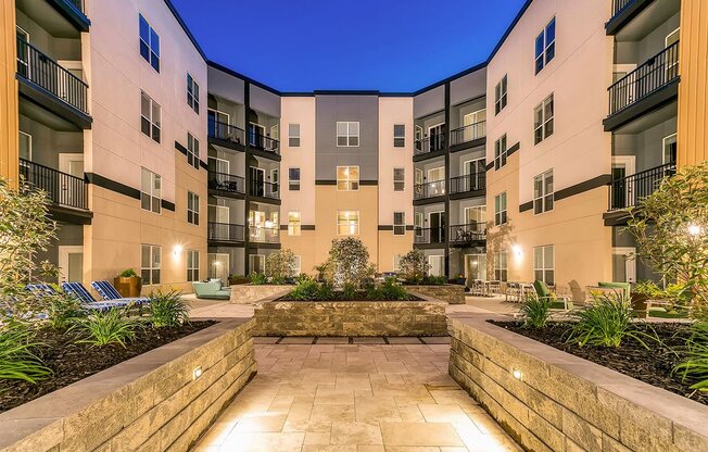 a courtyard with a stone wall in the middle of an apartment building at Aster Apartments, Beachwood, OH 44122