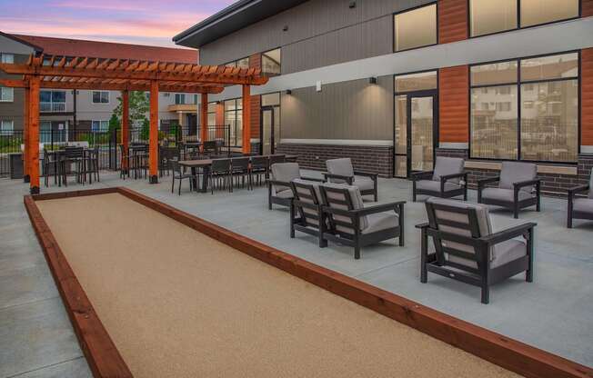 Outdoor patio with bocce ball court off the clubhouse with the pergolas in the background.