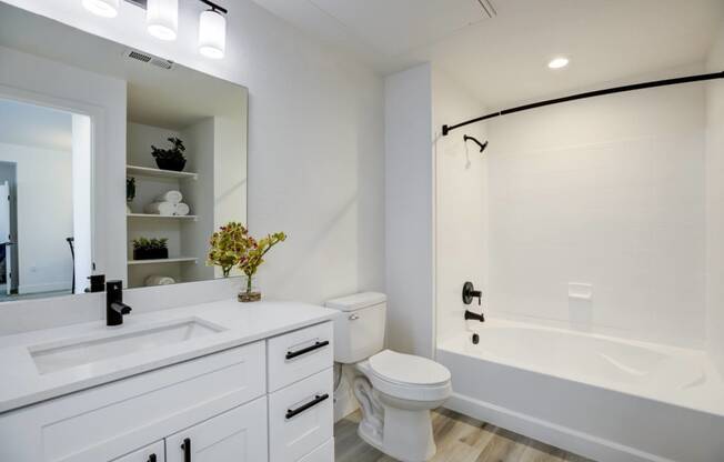 a white bathroom with a large mirror and a toilet