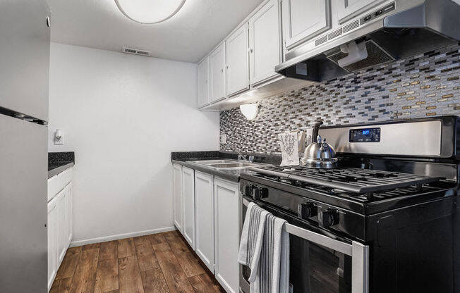 a kitchen with black appliances and white cabinets