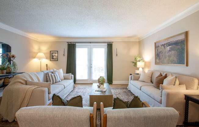A living room with a grey sofa, a white armchair, and a wooden coffee table.