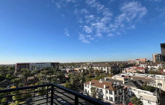 a balcony with a view of the city and palm trees