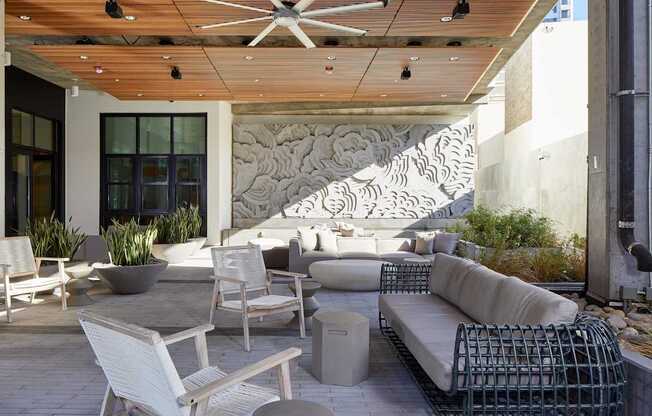 A patio with a white chair and a white couch.