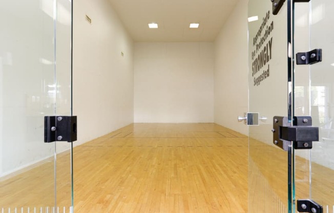 a squash court in a room with glass doors