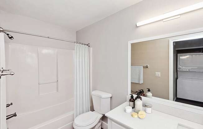 Model Bathroom with White Cabinets, Wood-Style Flooring and Shower/Tub at Vue at Baymeadows Apartments in Jacksonville, FL.