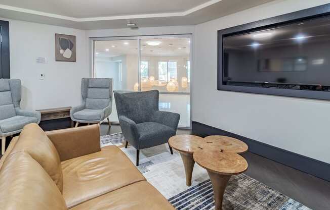 a living room with a couch and chairs and a television