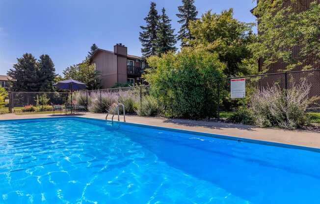 a pool with a fence and house in the background at Lincoln Village Apartments, Washington, 99208