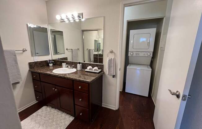 A bathroom with a brown vanity and a white towel.