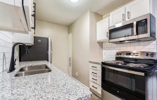 A kitchen with granite countertops and stainless steel appliances.