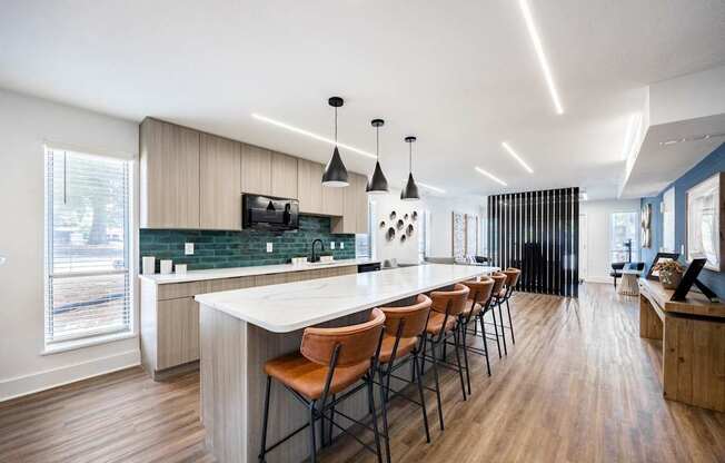 a communal kitchen with a marble counter top and bar stools