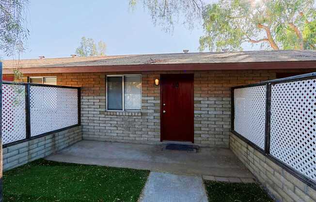 A house with a red door and a black and white fence.