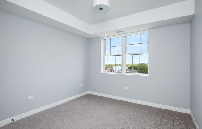 an empty room with white walls and a window