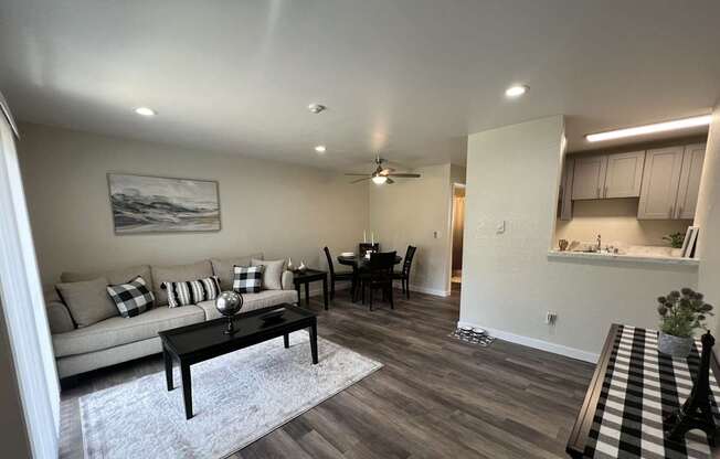 A living room with a couch, coffee table, and a painting on the wall.