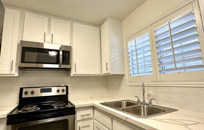 a kitchen with stainless steel appliances and white cabinets