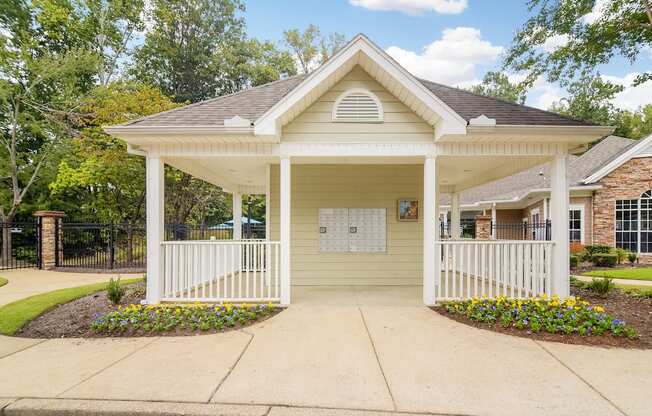 the front porch of a yellow house with a porch swing