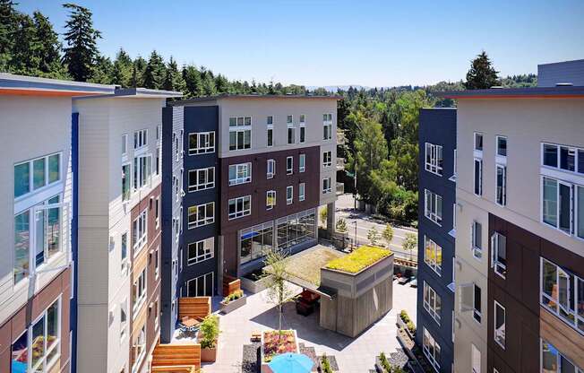 A view of a courtyard with a green roof and a pool surrounded by buildings. at Kirkland Crossing Apartments, Washington, 98033