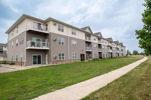 a large apartment complex with a grassy area in front of it