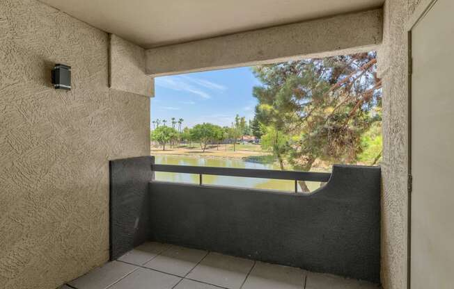 A balcony with a view of a green landscape.