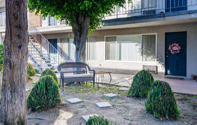 a bench sitting under a tree in front of a building