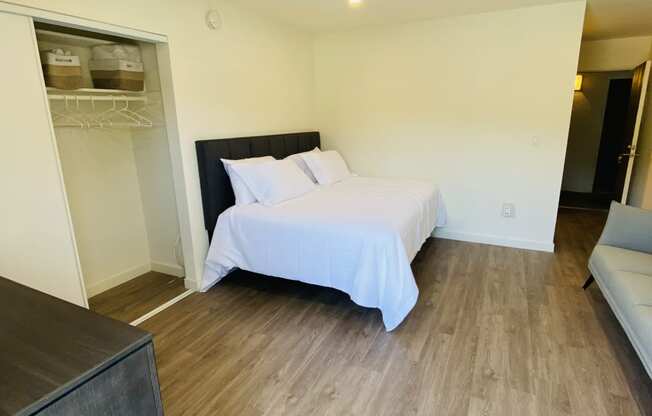 a bedroom with a white bed and a wooden floor