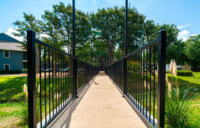 a bridge with a black iron fence over a sidewalk