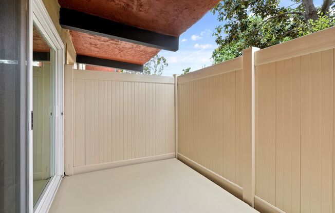 a porch with a fence and a blue sky in the background