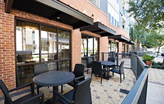 a patio with tables and chairs outside of a building