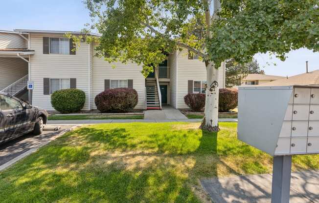 a white house with a yard and a mailbox in front of it