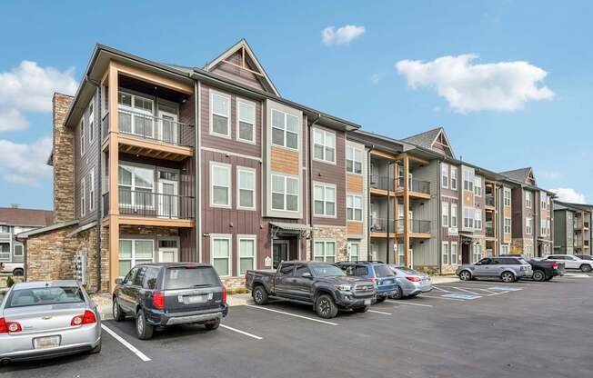 a parking lot with cars in front of an apartment building at The Quarry Luxury Apartment Homes, Colorado