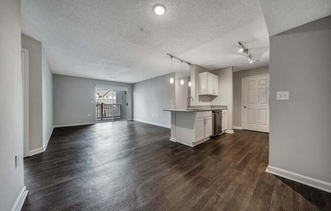 A kitchen with white cabinets and a wooden floor.