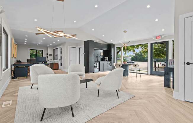 A modern living room with white chairs and a grey rug.