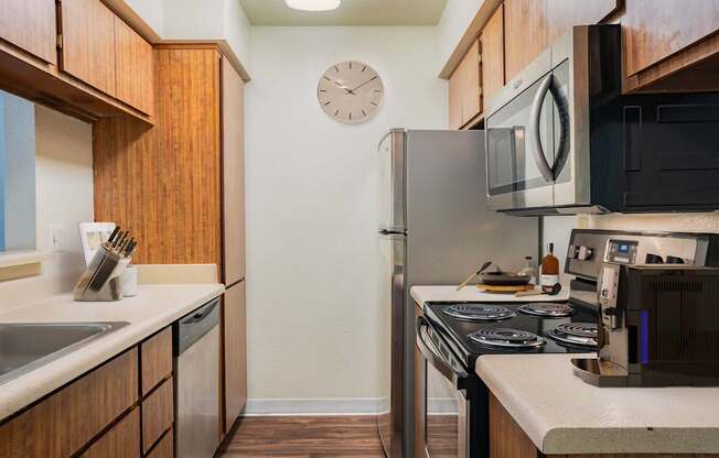 A kitchen with a stove, sink, and refrigerator.