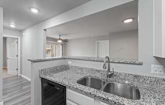 A modern kitchen with granite countertops and stainless steel appliances.