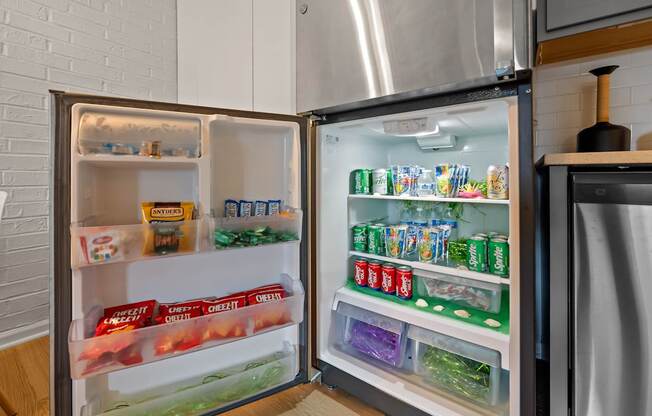 A refrigerator is open, showing a variety of food items on the shelves.