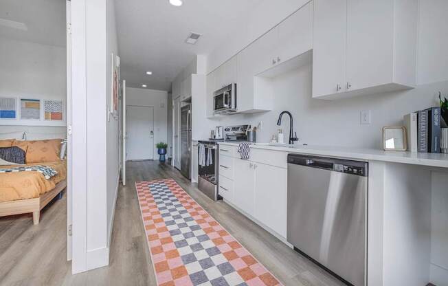 A kitchen with a checkered rug on the floor.