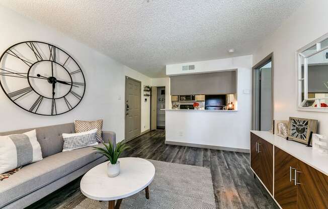 an open living room and kitchen with a large clock on the wall