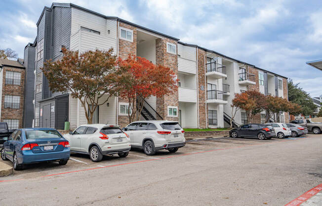 an apartment building with cars parked in front of it