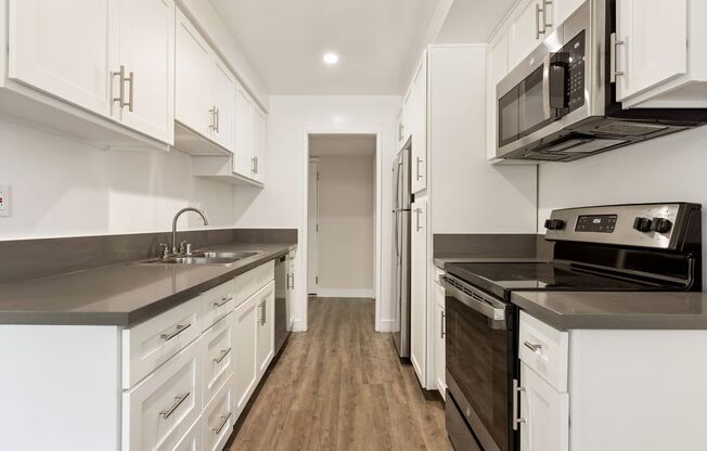 a kitchen with white cabinets and stainless steel appliances